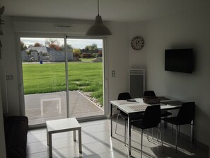 Relax in this stylish room with a dining area, flat-screen TV, and sliding glass door to an outdoor space.