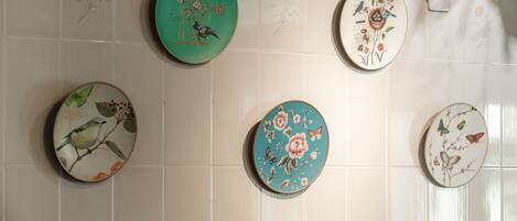 Una pared con cinco platos de cerámica decorados con diseños de pájaros y flores.