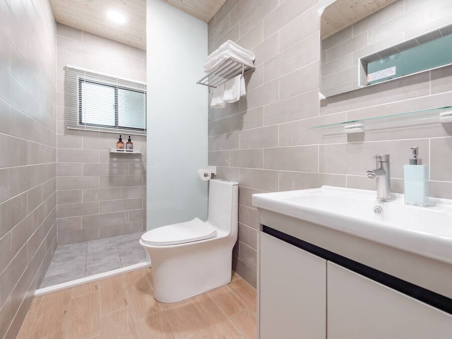 A modern bathroom with a toilet, sink, and shower area.