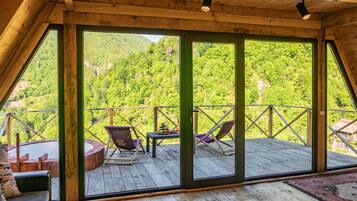 Une terrasse en bois offrant une vue panoramique sur une montagne boisée.