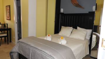 Een hotelkamer met een bed, een stoel, een schilderij en een spiegel.