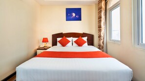 A hotel room with a large bed, red pillows, a nightstand with a lamp, a painting on the wall, and a window with curtains. - HANZ Boutique Hotel Ben Thanh (Ho Chi Minh City)