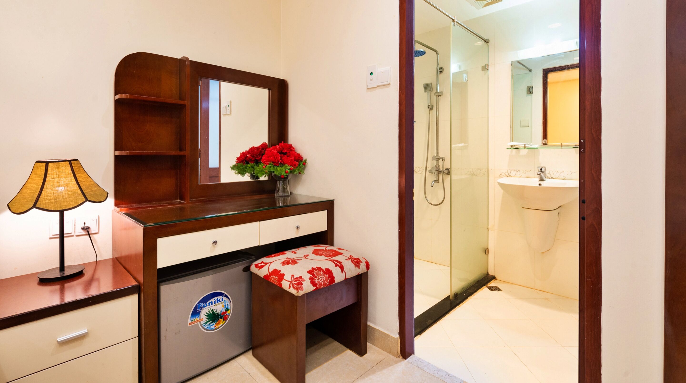 A bathroom with a glass shower enclosure, a sink, and a vanity with a mirror.