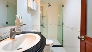 A bathroom with a large sink, toilet, and glass shower enclosure. - HANZ Boutique Hotel Ben Thanh (Ho Chi Minh City)