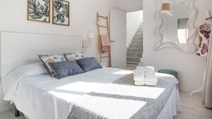 Ein Schlafzimmer mit einem Bett, einer Himmelsleiter, einem Spiegel und Bildern an der Wand.