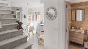 Ein modernes Interieur mit Treppe, Essbereich und Badezimmer mit Holzausstattung und Spiegel.