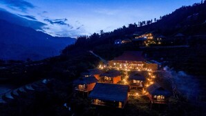 A traditional building with multiple rooms, surrounded by terraced fields and a mountainous backdrop. - Sapa Rosie House - Mountain Retreat (Sa Pa)
