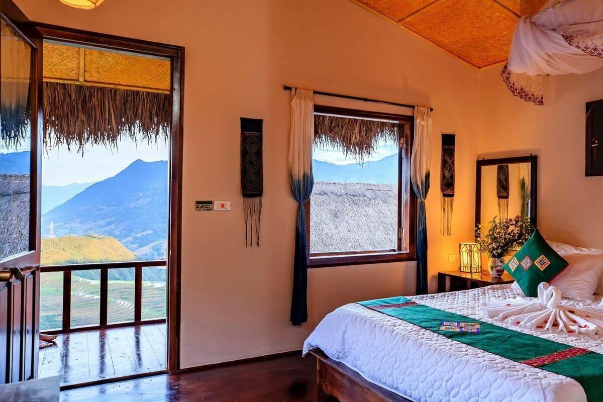 Un dormitorio con una cama grande, vistas a las montañas y un balcón.