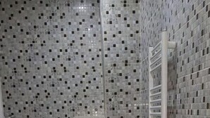 A bathroom with a toilet and sink, tiled walls, and a tiled floor. - 4:ain el Turck Superbe Appartement en Résidence (Aïn El Turk)