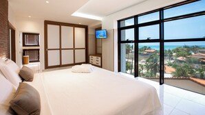 A bedroom with a large bed, a TV, a wardrobe, and a view of the sea. - VM Hotel Cumbuco (Caucaia)