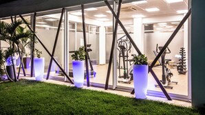 A modern building with large windows and a gym visible inside. - VM Hotel Cumbuco (Caucaia)