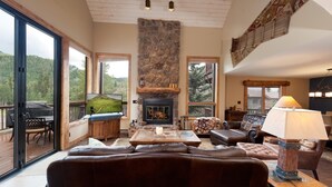 A cozy living room with a fireplace, leather sofas, a coffee table, and a TV. - Corner Cascade Village Condo - Largest deck - Fire Pit - Views - Heated Pool (Durango)