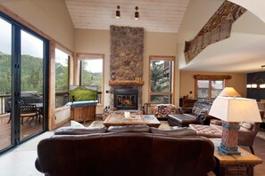 A cozy living room with a fireplace, leather sofas, a coffee table, and a TV. - Corner Cascade Village Condo - Largest deck - Fire Pit - Views - Heated Pool (Durango)