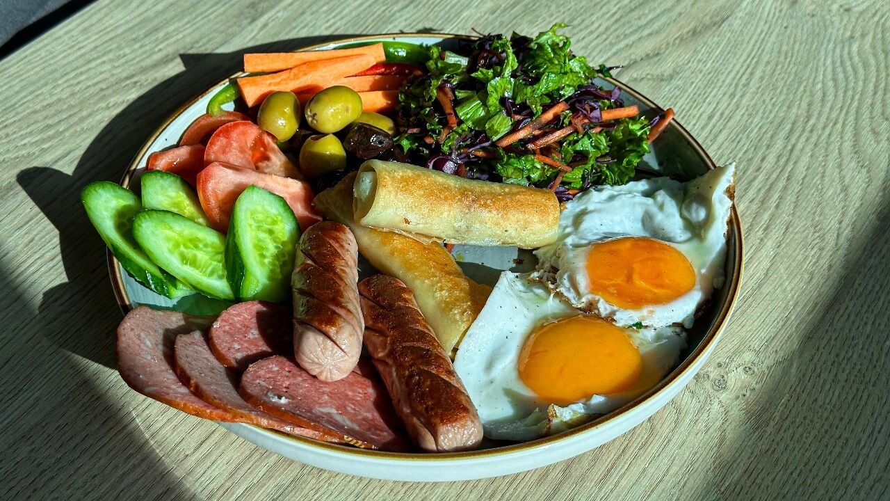 A plate of food including eggs, sausages, and vegetables.