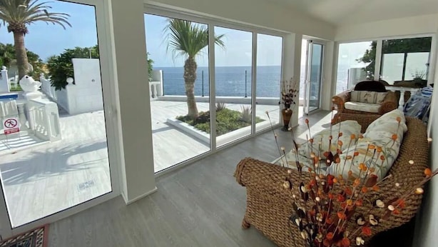 A spacious living room with large windows, a wicker sofa, and a view of the sea. - ¡nuevo! Villa Blanca. Besado por el sol y el Océano (Callao Salvaje)