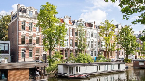 Ein Gebäude am Kanal mit einem vor Anker liegenden Boot, umgeben von traditioneller europäischer Architektur.