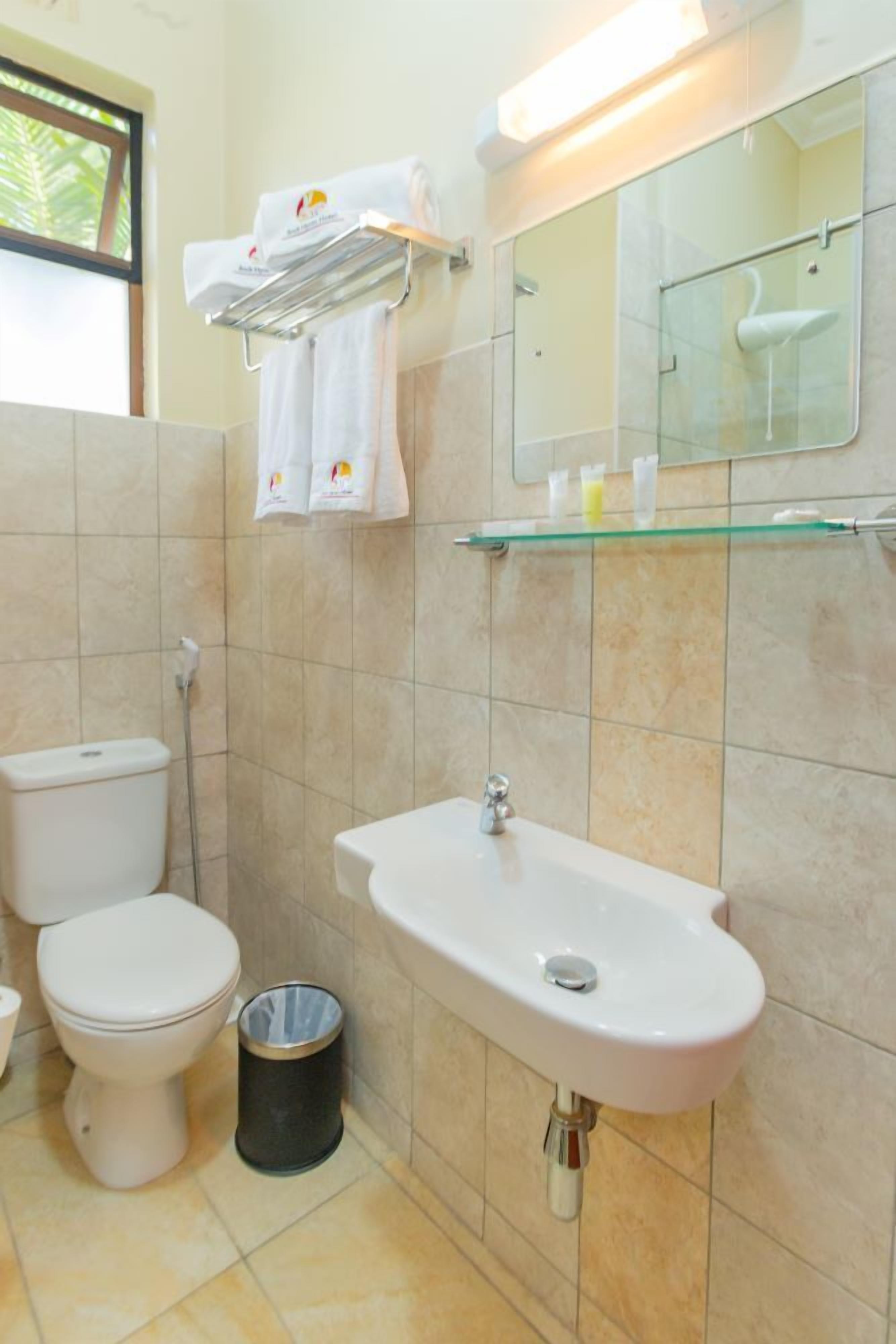 Une salle de bain comprenant des toilettes, un lavabo et une douche à paroi de verre.