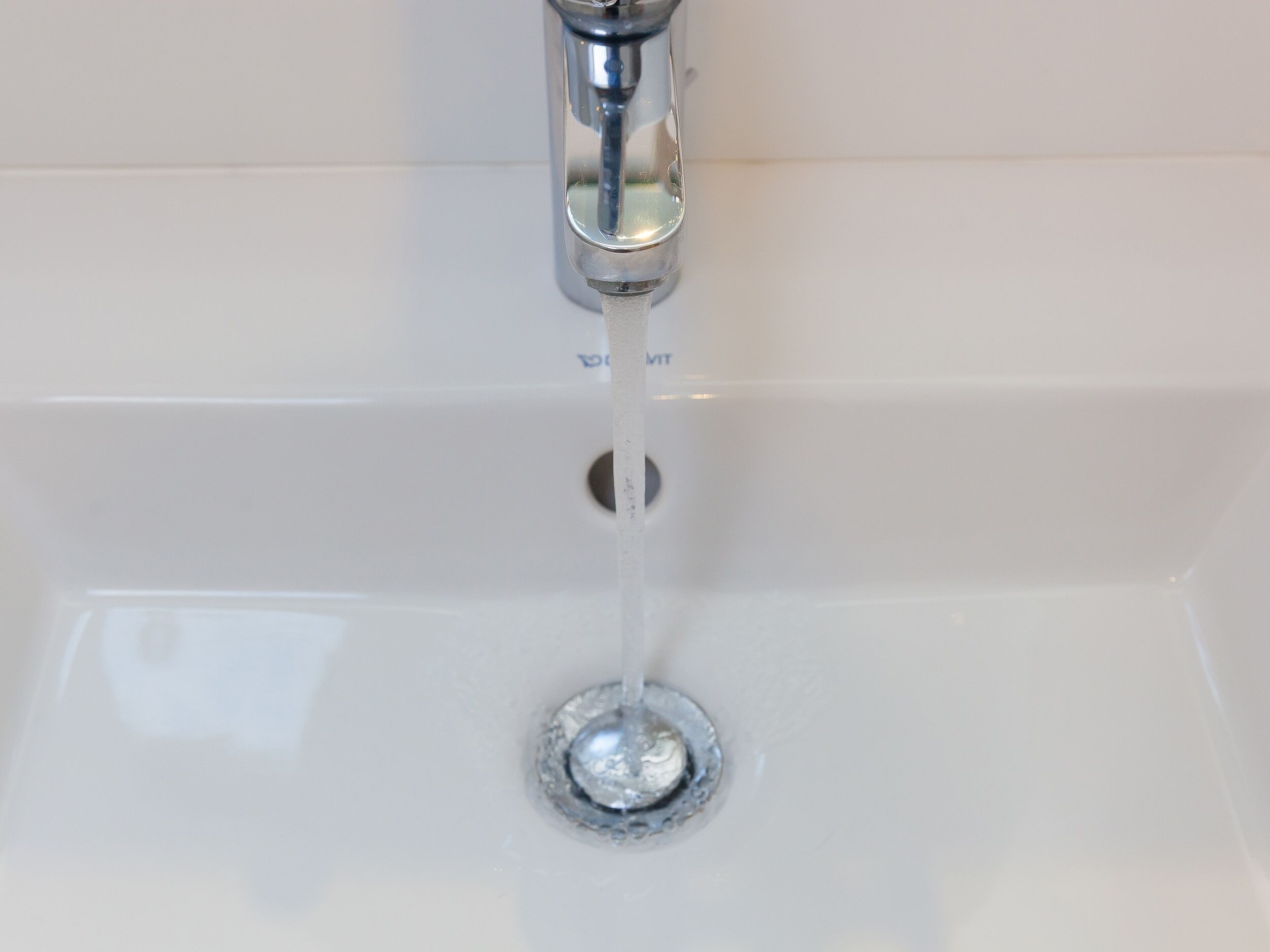 A bathroom sink with a chrome faucet and a drain.