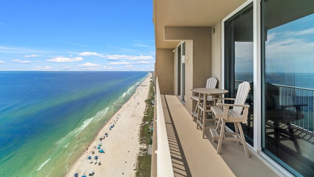 Un balcon avec vue sur une plage et l’océan.