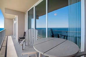 Ein Balkon mit Tisch und Stühlen mit Blick aufs Meer.