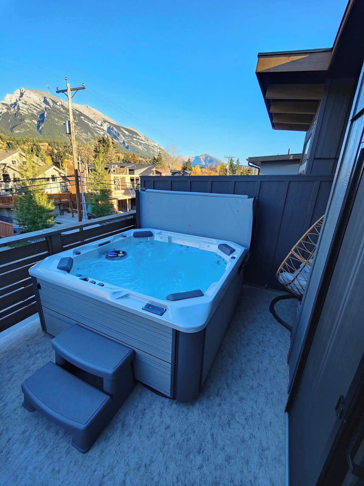 Un jacuzzi en un balcón con vista a la montaña.