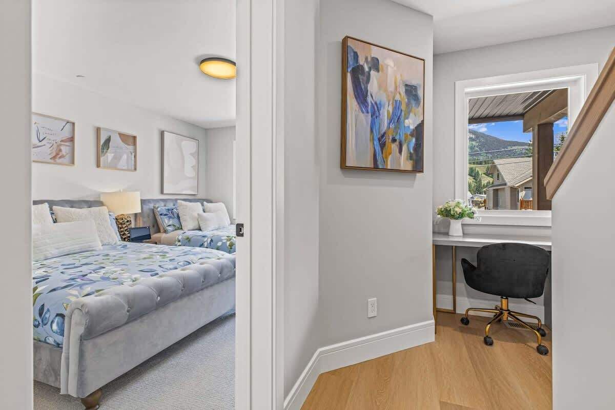 A bedroom with a bed, bedside table, lamp, and wall art.
