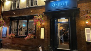 A traditional pub named "The Market House" with a signboard, flower baskets, and a visible entrance. - Market House (Glastonbury)