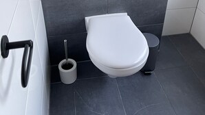 Ein modernes Badezimmer mit Toilette, Bidet und Handtrockner.