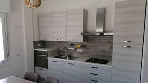 A modern kitchen with grey cabinets, a stainless steel range hood, and a built-in dishwasher. - Very central and airy apartment in Palau (Palau)