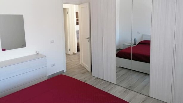 A bedroom with a bed, a wardrobe, a mirror, and an air conditioning unit. - Very central and airy apartment in Palau (Palau)