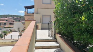 A residential building with a balcony, a satellite dish, and a gate leading to the entrance. - Very central and airy apartment in Palau (Palau)