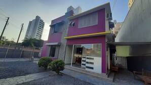 Un edificio de dos pisos con fachada morada y detalles en amarillo.