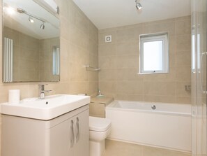 A modern bathroom with a bathtub, a toilet, and a sink. - Waters Watch (St Ives)