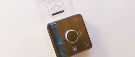A thermostat with a target temperature setting and a card with instructions.