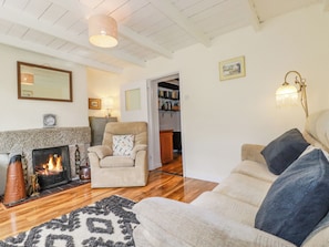 Una sala de estar acogedora con chimenea, un sillón cómodo y un sofá.