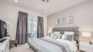 A modern hotel room with a large bed, a desk, and a TV. - Last Minute Disney Getaway! Private Pool, Hot Tub & Game Room. Book Now! #41843 (Orlando)