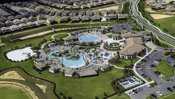 An aerial view of a residential area with a large swimming pool complex, multiple tennis courts, and a parking lot. - Last Minute Disney! Private Pool, Game Room & Themed Bedrooms. Book Now! #41935 (Orlando)