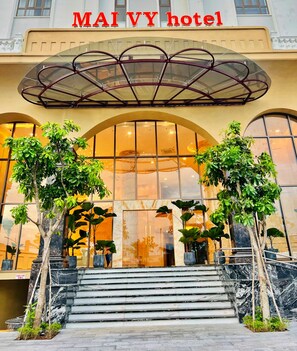 The entrance of MAIVY hotel with a glass canopy, marble steps, and potted plants. - Mai Vy Hotel Tay Ninh (Tan Ninh)