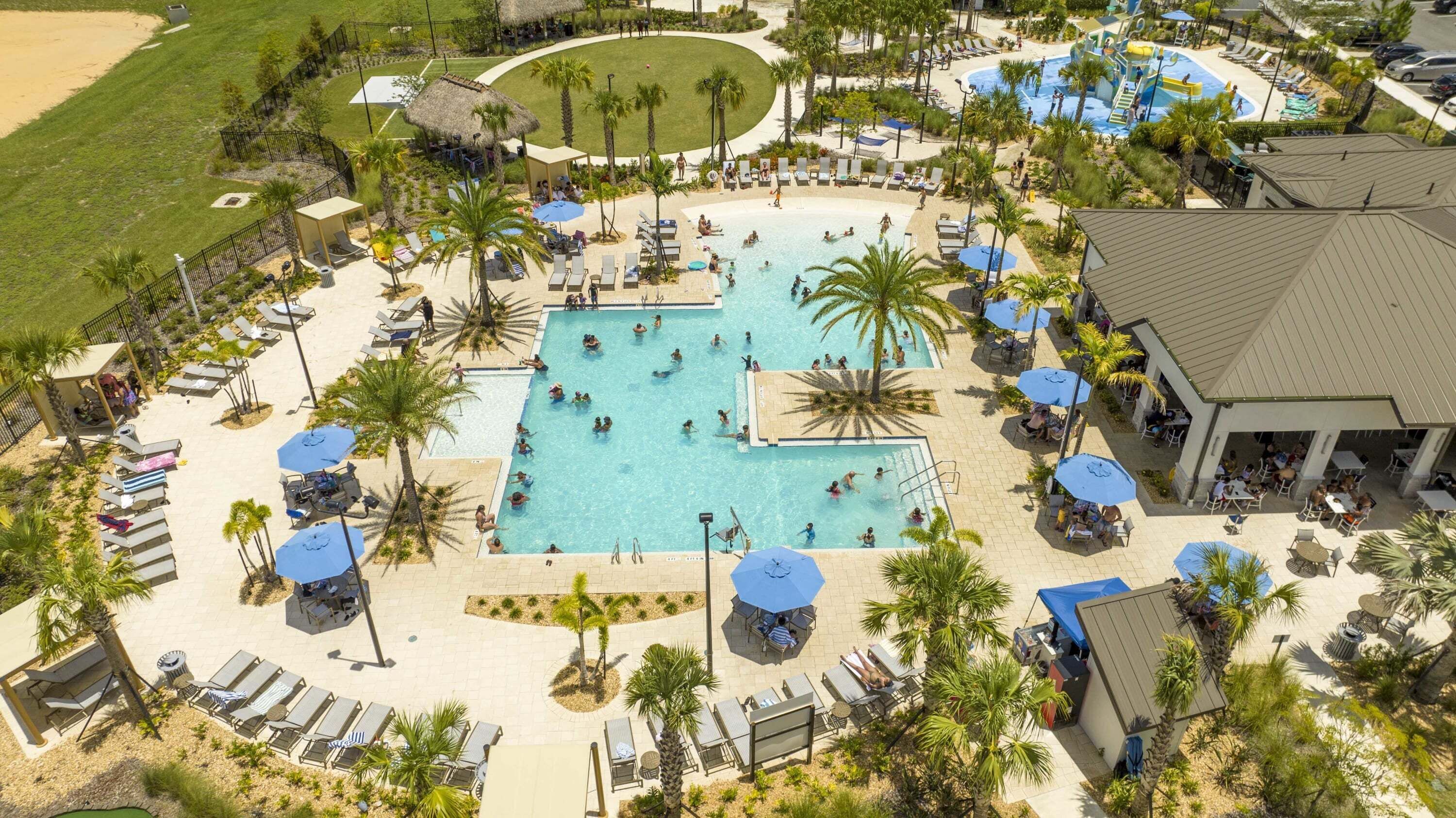 A resort with multiple swimming pools, sun loungers, and palm trees.