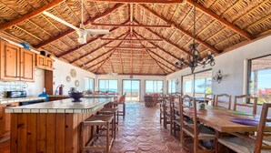 A spacious kitchen with a large island, wooden cabinets, and a thatched roof ceiling. - Directly on the Ocean in Cabo Pulmo with A/C! (Cabo Pulmo)