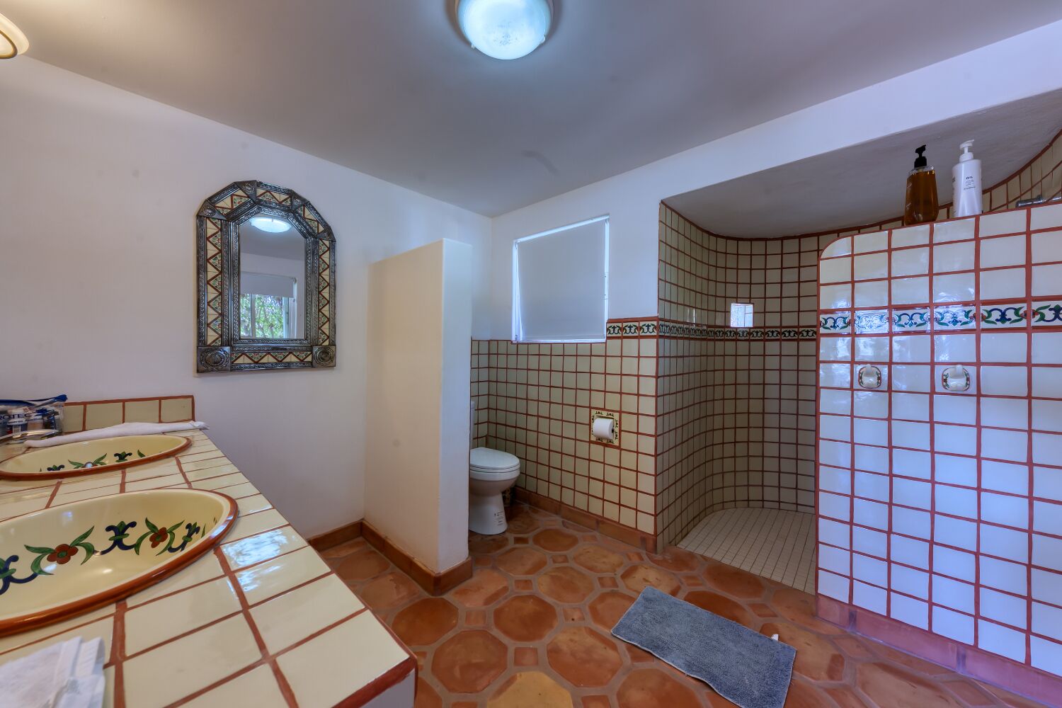 Ein Badezimmer mit Toilette, Waschbecken und Duschbereich.
