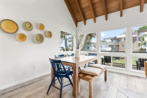 Enjoy meals in this dining area with a table and chairs, surrounded by windows offering a view of the neighborhood.