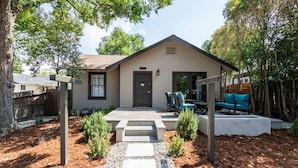 A house with a front porch, a door, and a seating area with chairs.