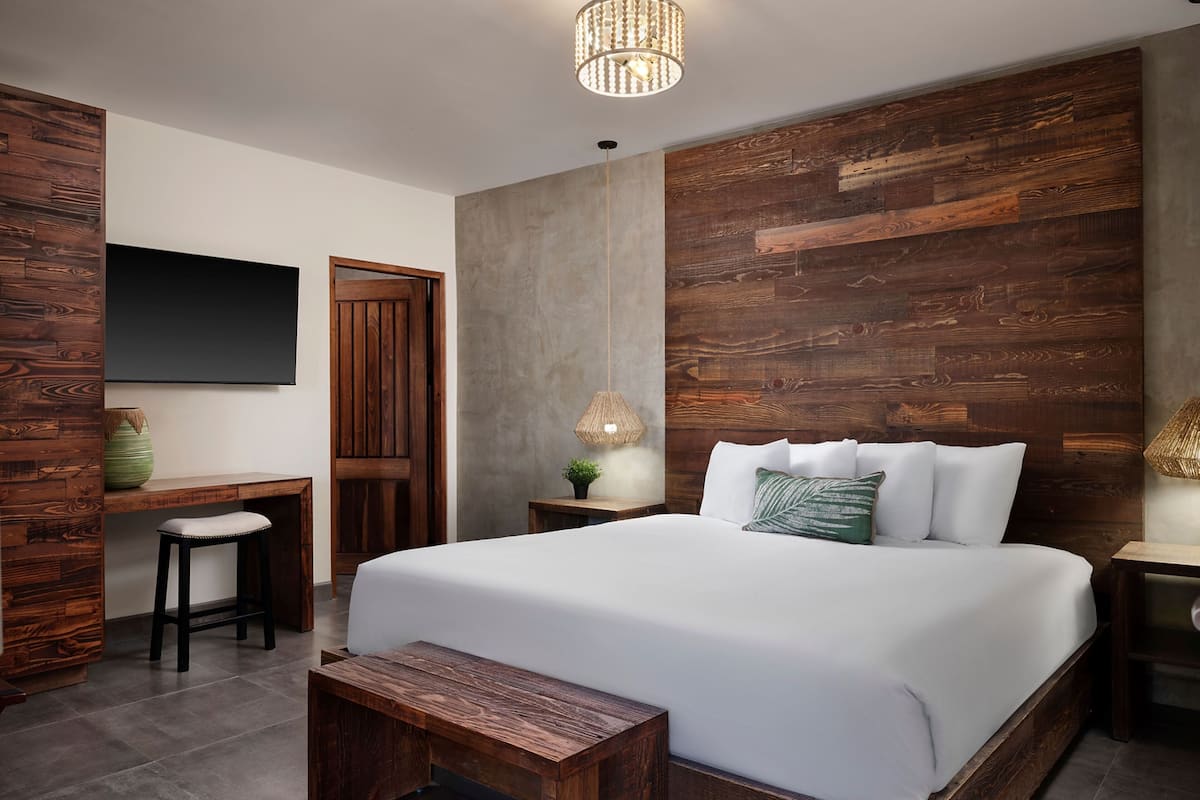Een moderne slaapkamer met een groot bed, een bureau en een stoel.
