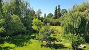 Een weelderig groen landschap met bomen en een klein gebouw.