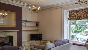 A living room with a fireplace, television, and seating area. - Peaceful village location within walking distance to Keswick. (Portinscale, Keswick)