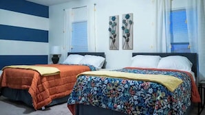A bedroom with two beds, each with a different style of bedding, a window with blinds, and a wall with a blue and white striped pattern. - Gorgeous Entire Home In Greensboro!!!! (Greensboro)