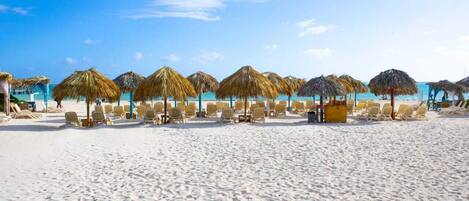 Una playa cerca, sillas reclinables de playa, toallas de playa