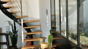 A modern interior with a wooden staircase, a wooden table with a cactus, and a large window with a view. - "Au gré des marées", panoramic sea view, beach 300 m, town 800 m. (Carantec)