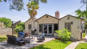 A house with a patio area featuring outdoor furniture, a satellite dish, and a small garden.